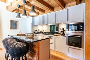 A kitchen with white cabinets and a bosch oven