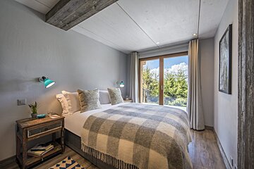 A bedroom with a bed a nightstand and a window