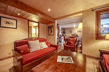 A living room with a red couch and a wooden table