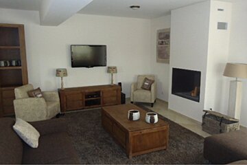 A living room with a fireplace and a flat screen tv