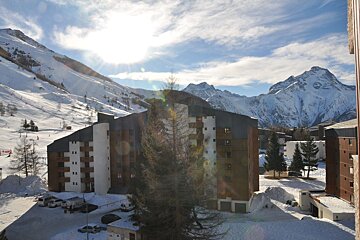 A view of a ski resort with mountains in the background