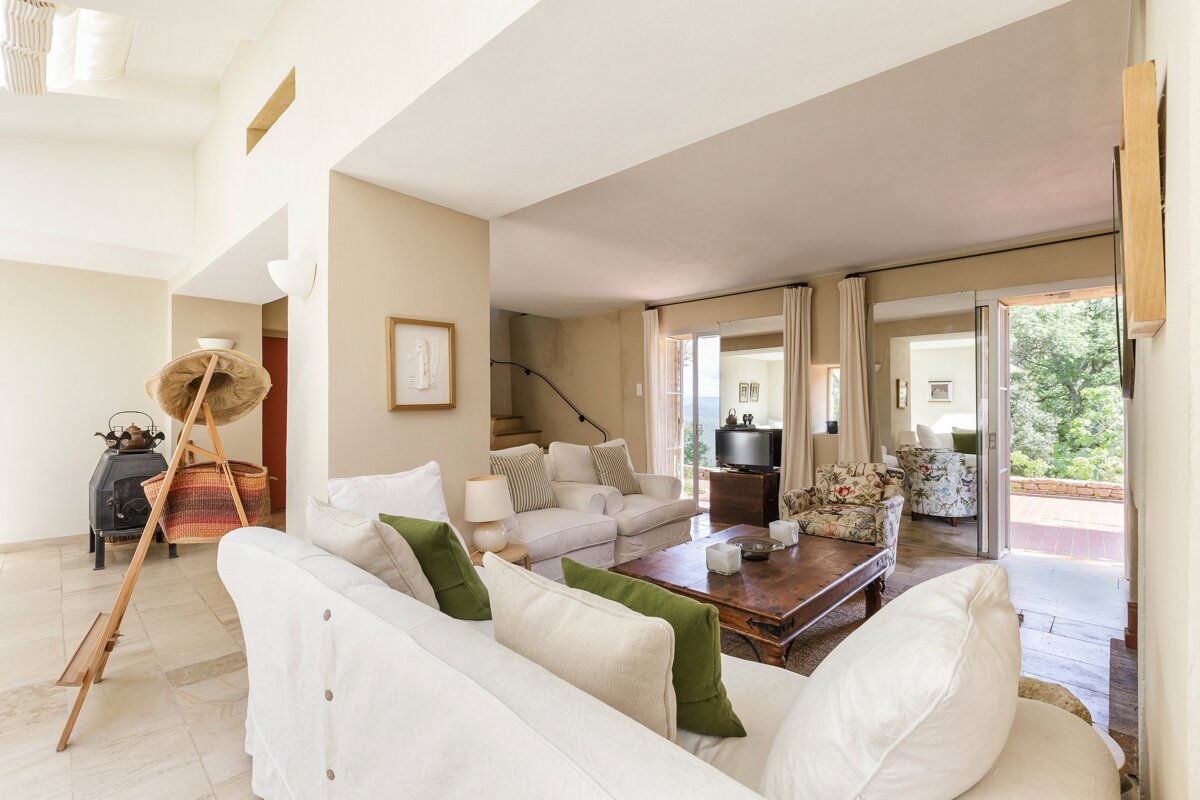 A living room with a white couch and green pillows