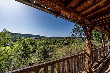 A wooden balcony overlooking a lush green forest