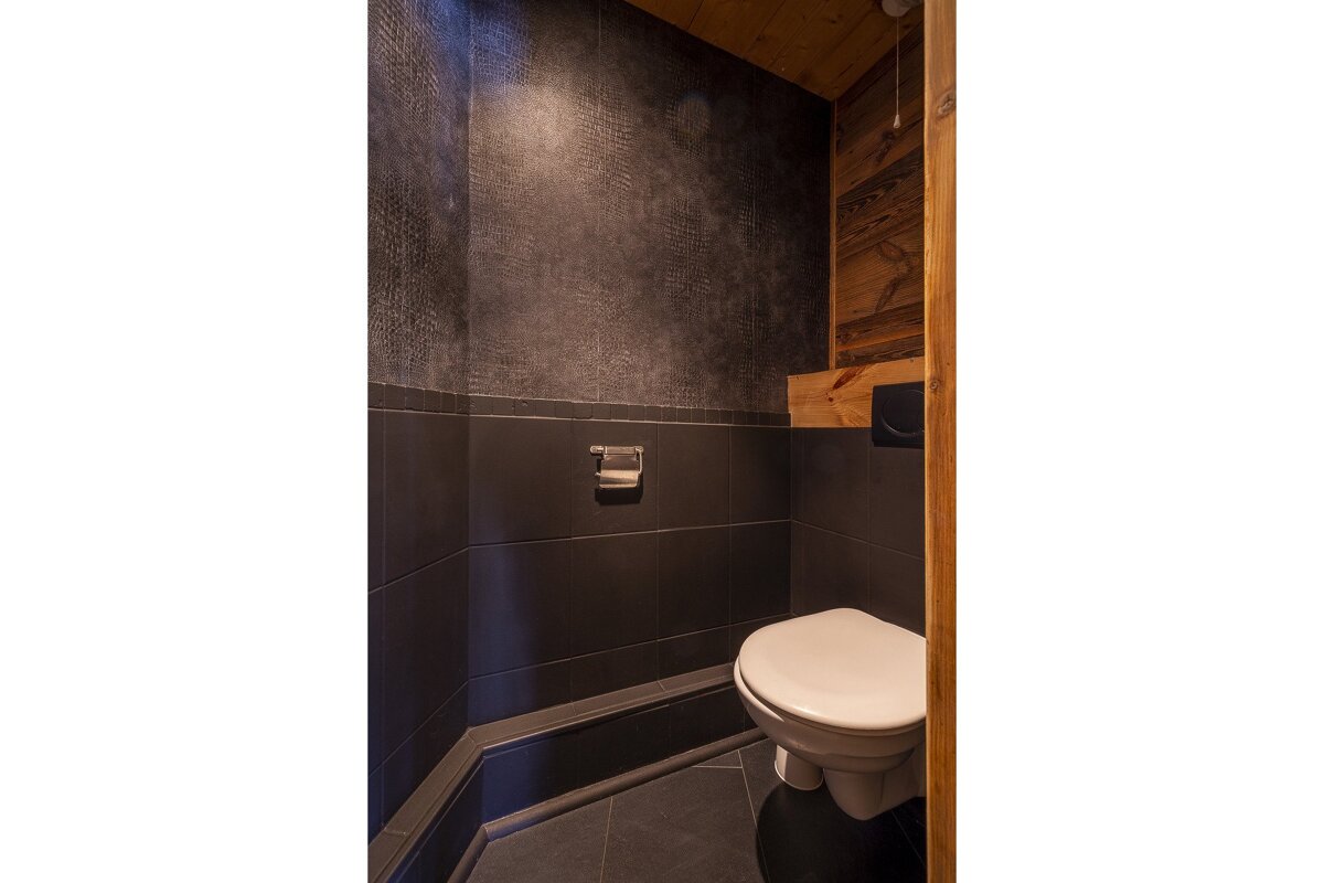 A bathroom with a toilet and a paper towel holder