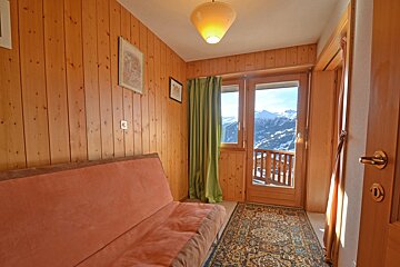 A wood paneled room with a couch and a rug