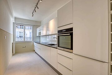 A kitchen with white cabinets and a stainless steel oven