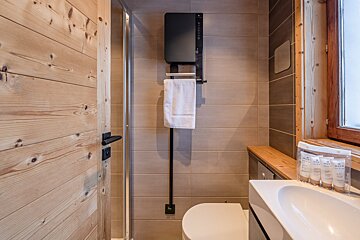 A bathroom with a toilet and a towel hanging on the wall