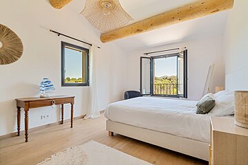 A bedroom with a large bed and a window