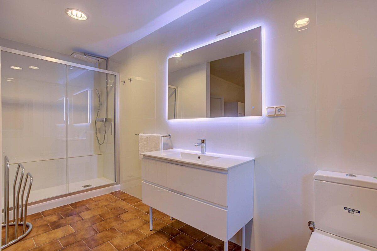 A bathroom with a toilet and a sink and a mirror