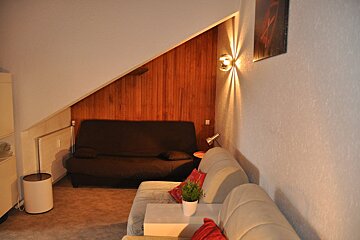 A living room with a couch and a picture on the wall