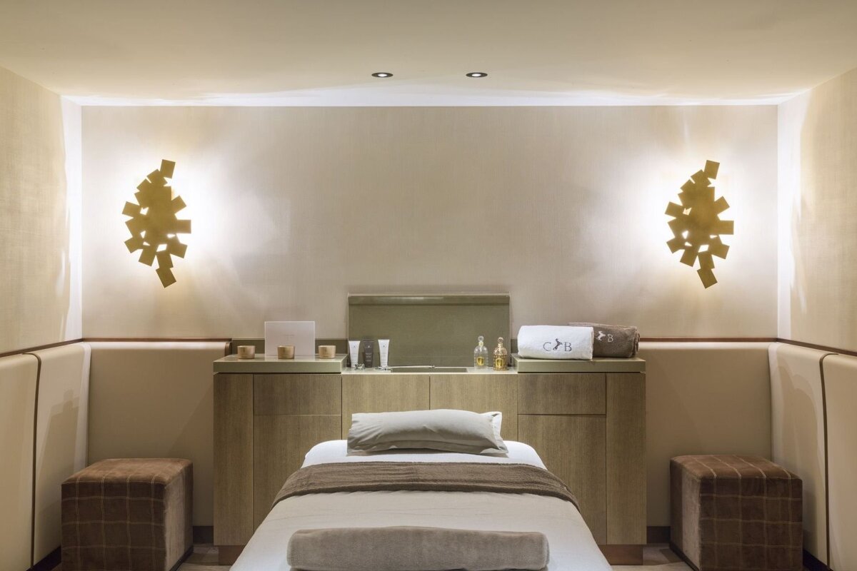 A room with a bed and two ottomans that says cb on it
