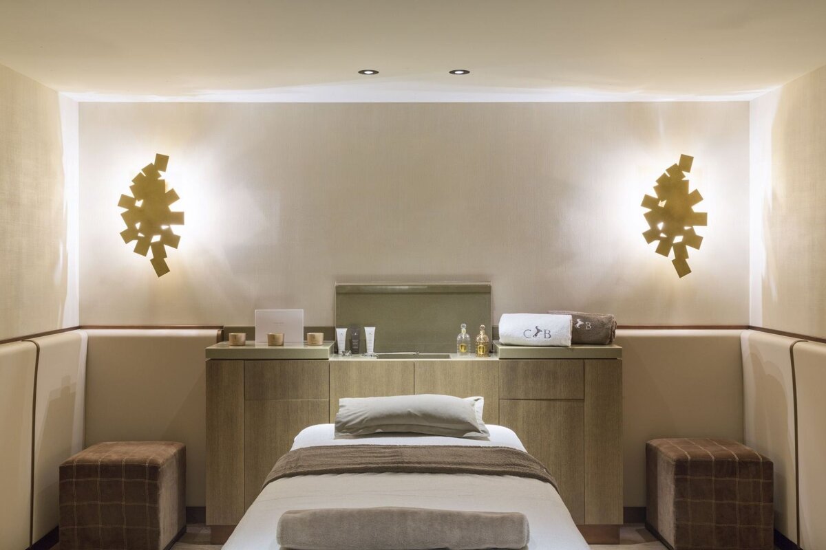 A room with a bed and two ottomans that says cb on it