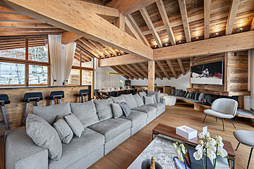 A living room with a large grey couch and a box that says ' champagne ' on it