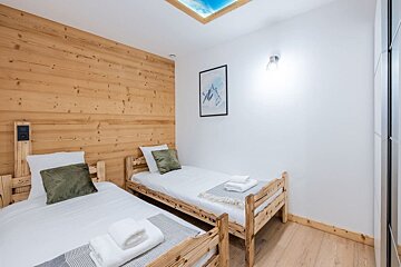 A bedroom with two beds and a picture on the wall