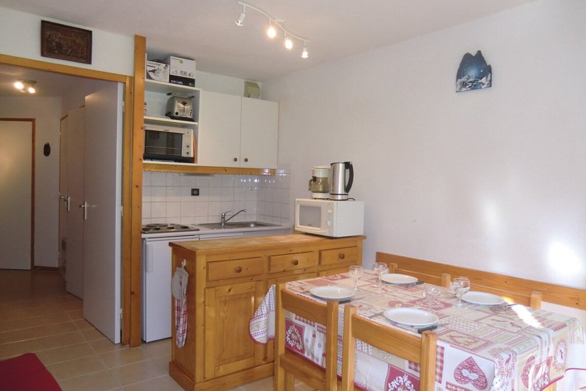 A kitchen with a table and chairs and a microwave