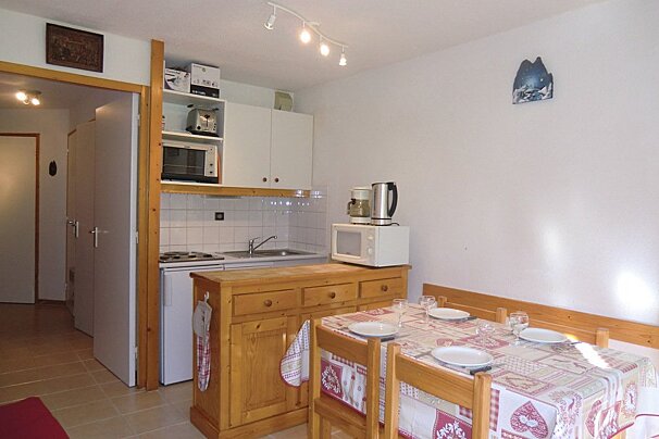 A kitchen with a table and chairs and a microwave
