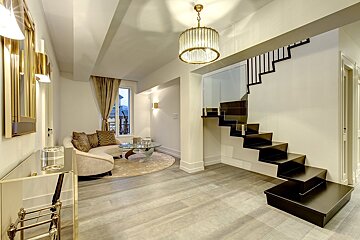 A living room with a staircase leading up to the second floor