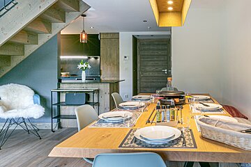 A dining room table with plates and utensils on it