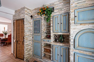 A room with blue cabinets and a brick wall
