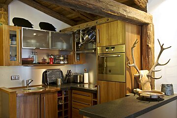 A kitchen with wooden cabinets and a stainless steel oven
