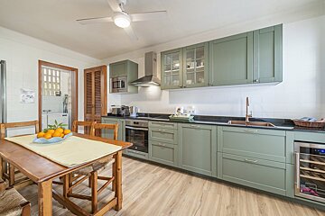 A kitchen with green cabinets and stainless steel appliances
