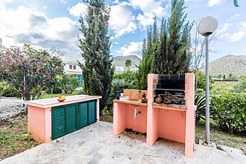 A pink and green outdoor kitchen with a sink and a grill