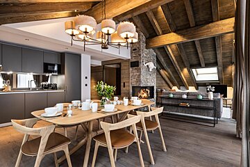 A dining room with a table and chairs and a fireplace