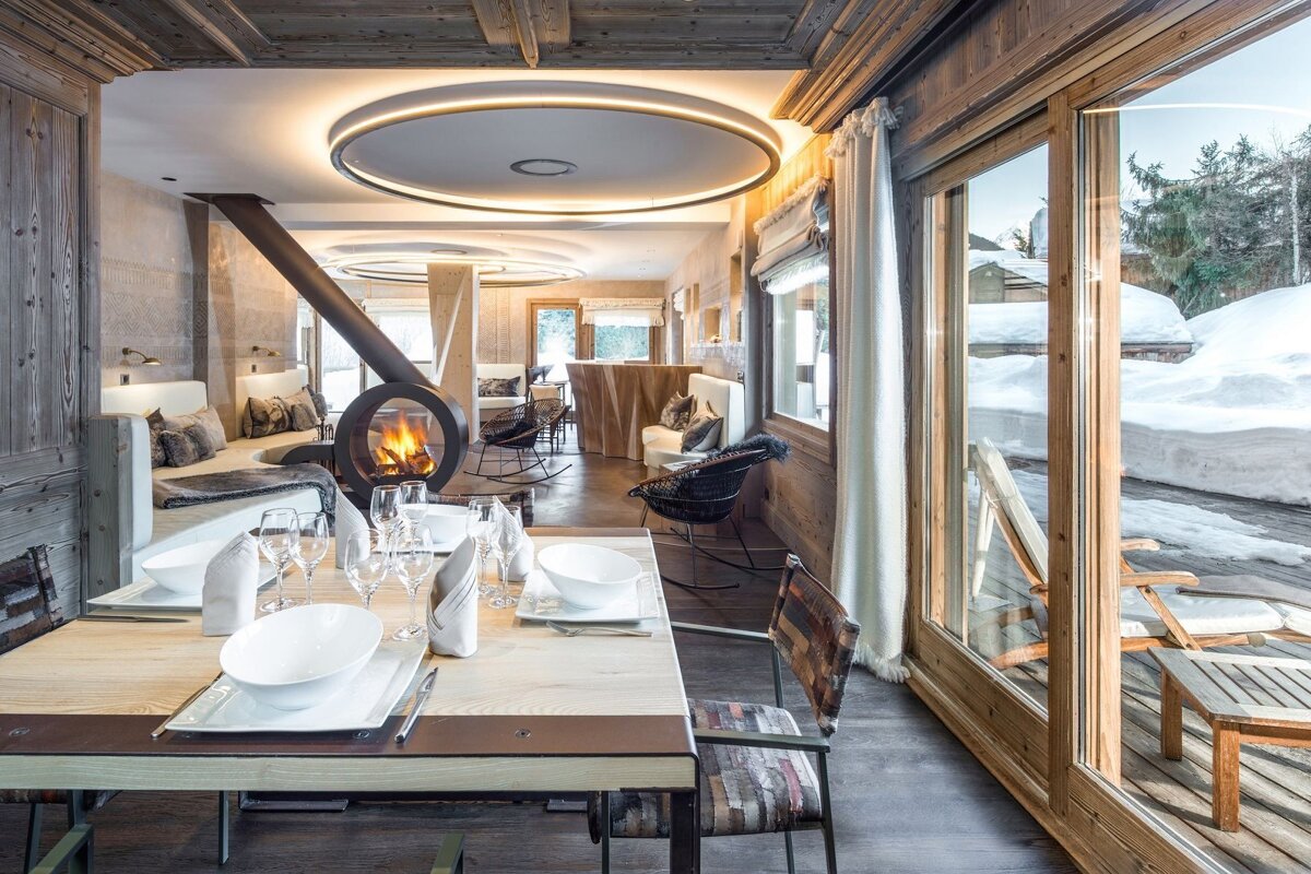 A room with a table and chairs and a fireplace