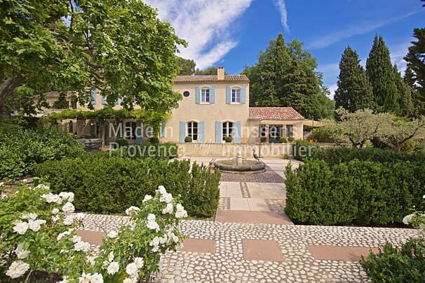 A large house with blue shutters is for sale in provence