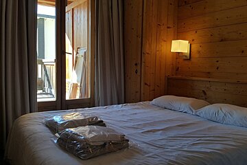 A hotel room with a bed and a window