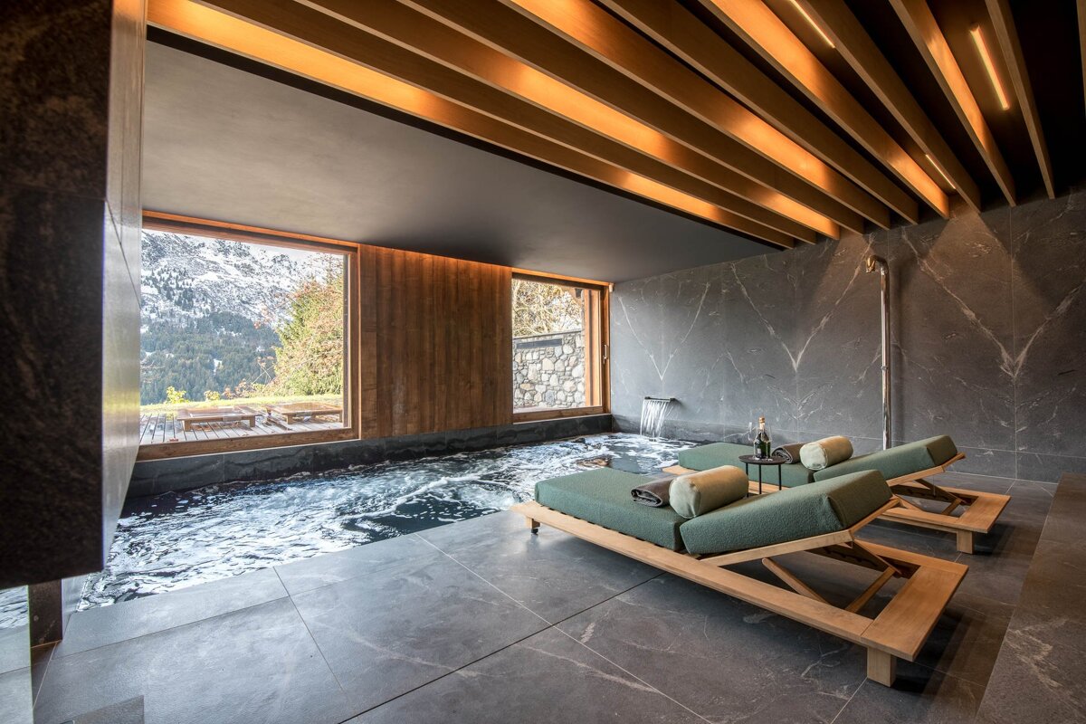 Two lounge chairs in a room with a swimming pool