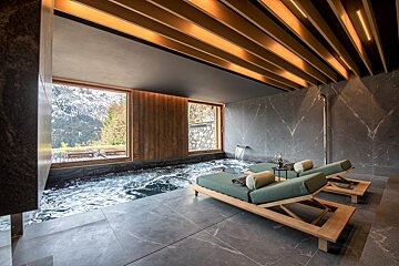 Two lounge chairs in a room with a swimming pool