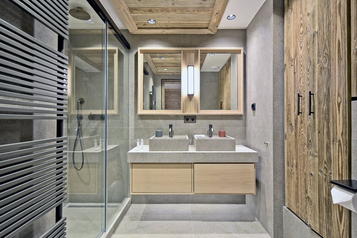 A bathroom with two sinks and a walk in shower