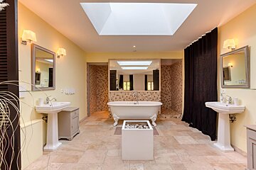 A bathroom with a claw foot tub and two sinks