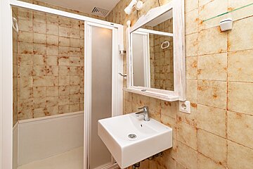 A bathroom with a sink a mirror and a shower