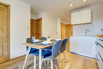 A kitchen with a table and chairs and a sink