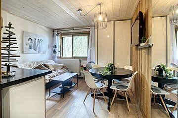 A living room with a painting of penguins on the wall