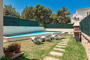 A fence surrounds a swimming pool with a sign that says no diving