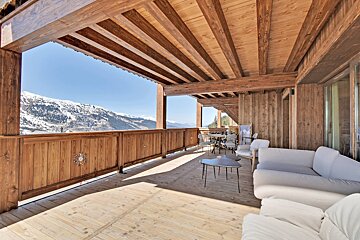 A wooden balcony with a view of the mountains