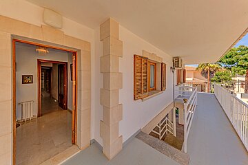 A white building with a balcony and stairs