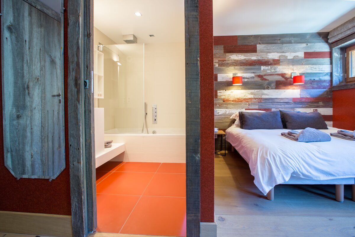 A bedroom with a bed and a bathtub in it