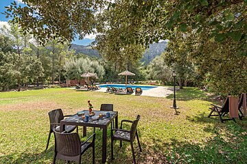 A table and chairs in front of a swimming pool