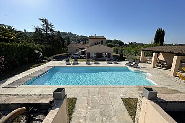 A large swimming pool in front of a house