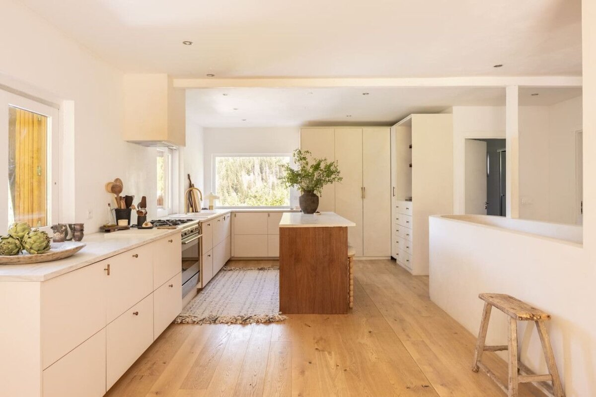 A kitchen with white cabinets and a wooden island
