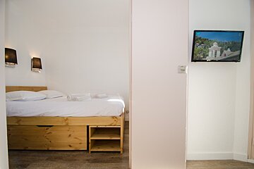 A bedroom with a bed and a flat screen tv