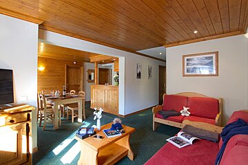 A living room with a red couch and a table