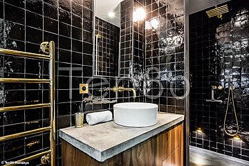 A bathroom with black tiles and a white sink