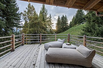 A wooden deck with two lounge chairs on it
