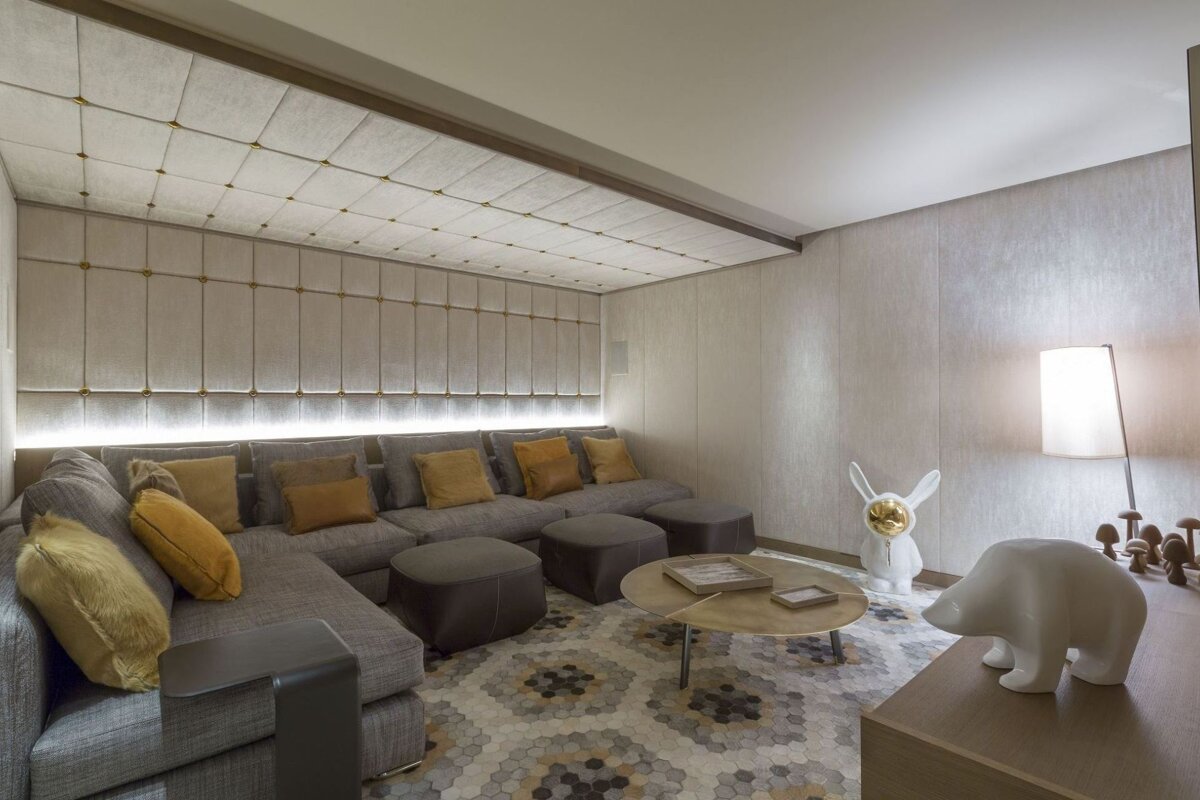 A living room with a sectional couch and ottomans