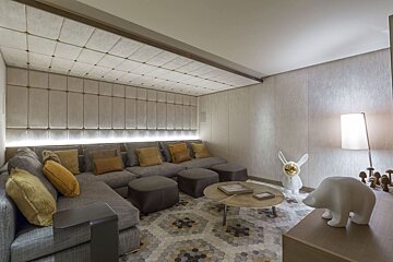 A living room with a sectional couch and ottomans